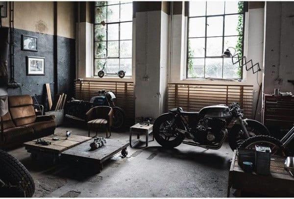 Garage retreat: Cozy space with a motorcycle, leather sofa, large windows, tools, and unique decorations