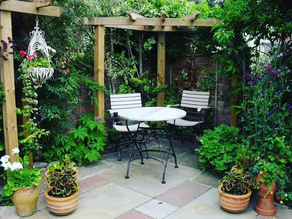 small corner garden patio with table and chairs 