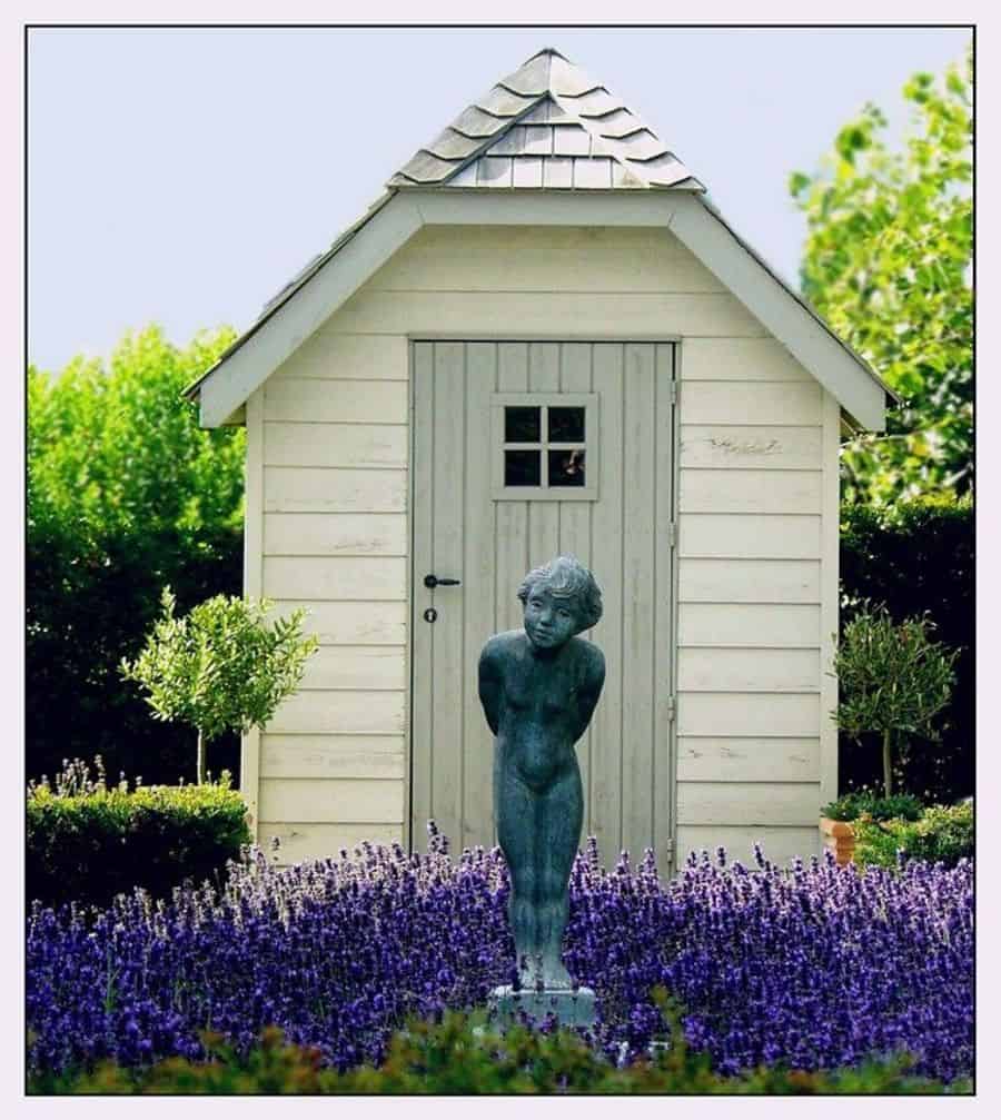 small white wood shed blue woman garden statue lavender