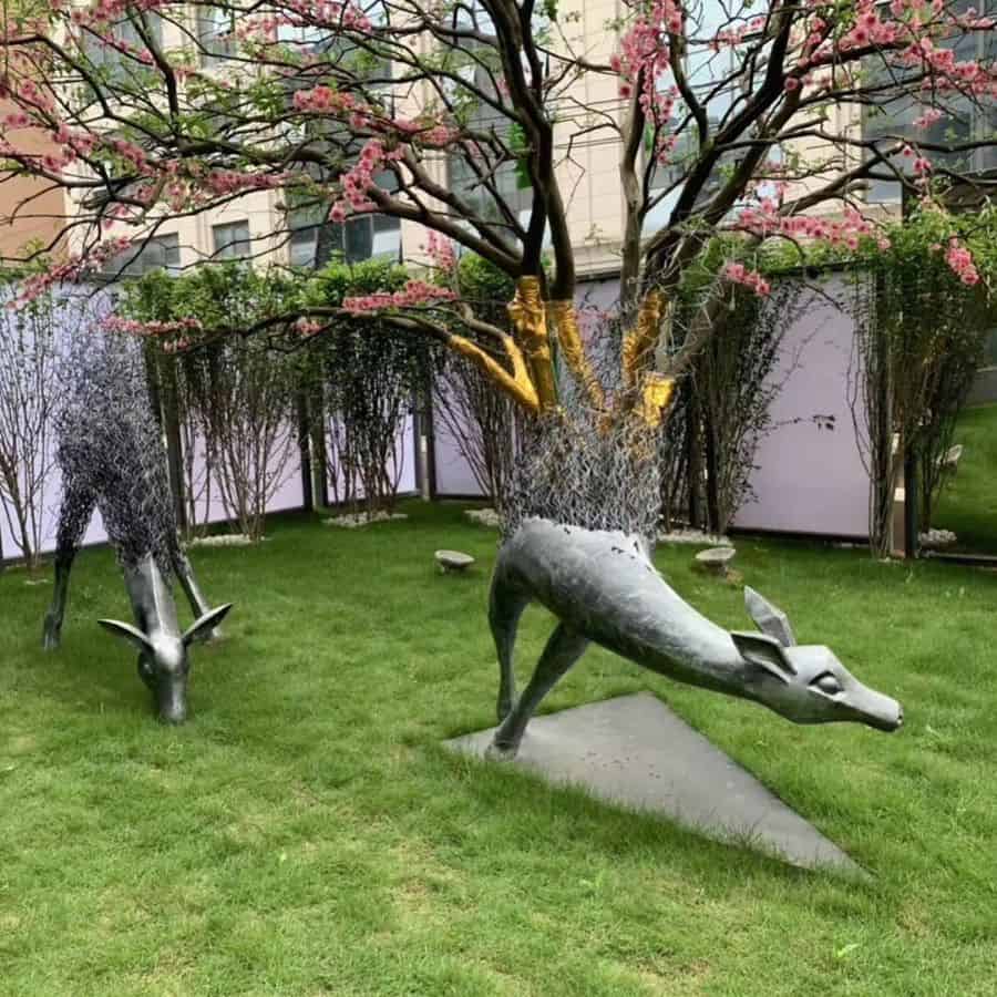 deer garden statues white fence pink flowers