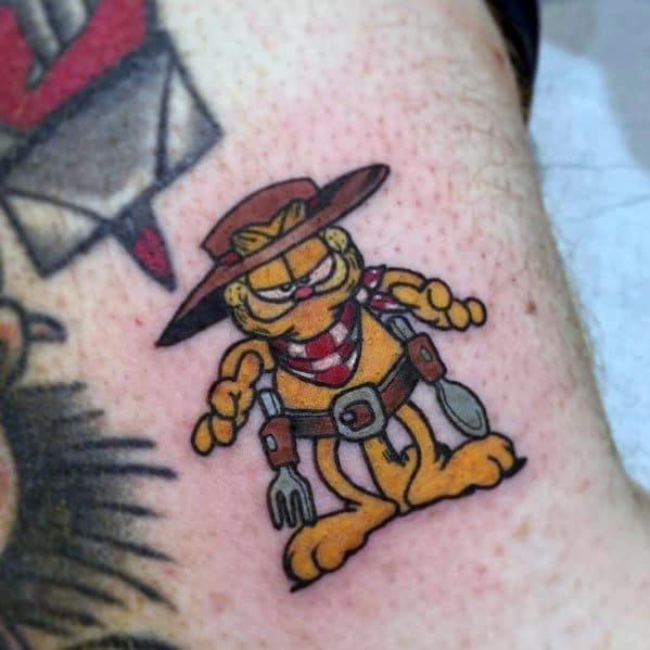 Garfield cowboy tattoo with a hat, bandana, and holsters—perfect for a fun, western-inspired design with a mischievous vibe.