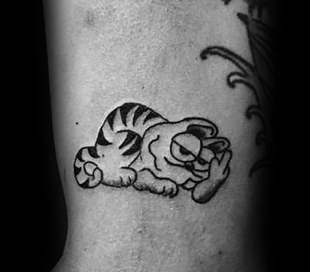 Small black and gray Garfield tattoo showing his signature lazy pose with a smug expression—perfect for a minimalist yet bold design.