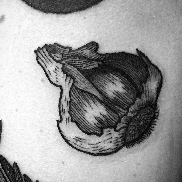 Black and grey garlic tattoo with bold shading and fine line details, creating a realistic and textured botanical design.