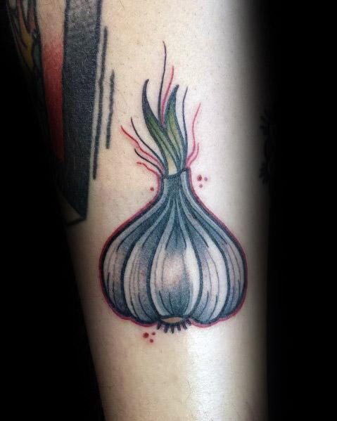 Bold garlic tattoo with vibrant shading, green sprouts, and red accents, creating a striking and modern botanical design.