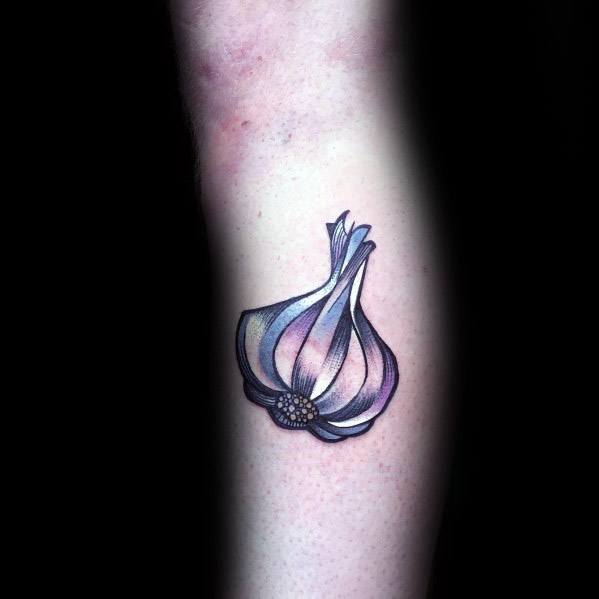 Stylized garlic tattoo with smooth shading and soft purple hues, creating a modern and artistic botanical design on the forearm.