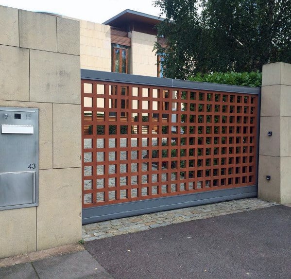 Modern sliding gate with a wooden grid design in a sleek metal frame.