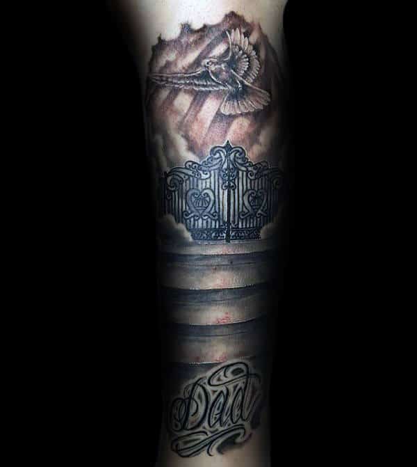 Tattoo of a dove, gates, and the word "Dad" on an arm