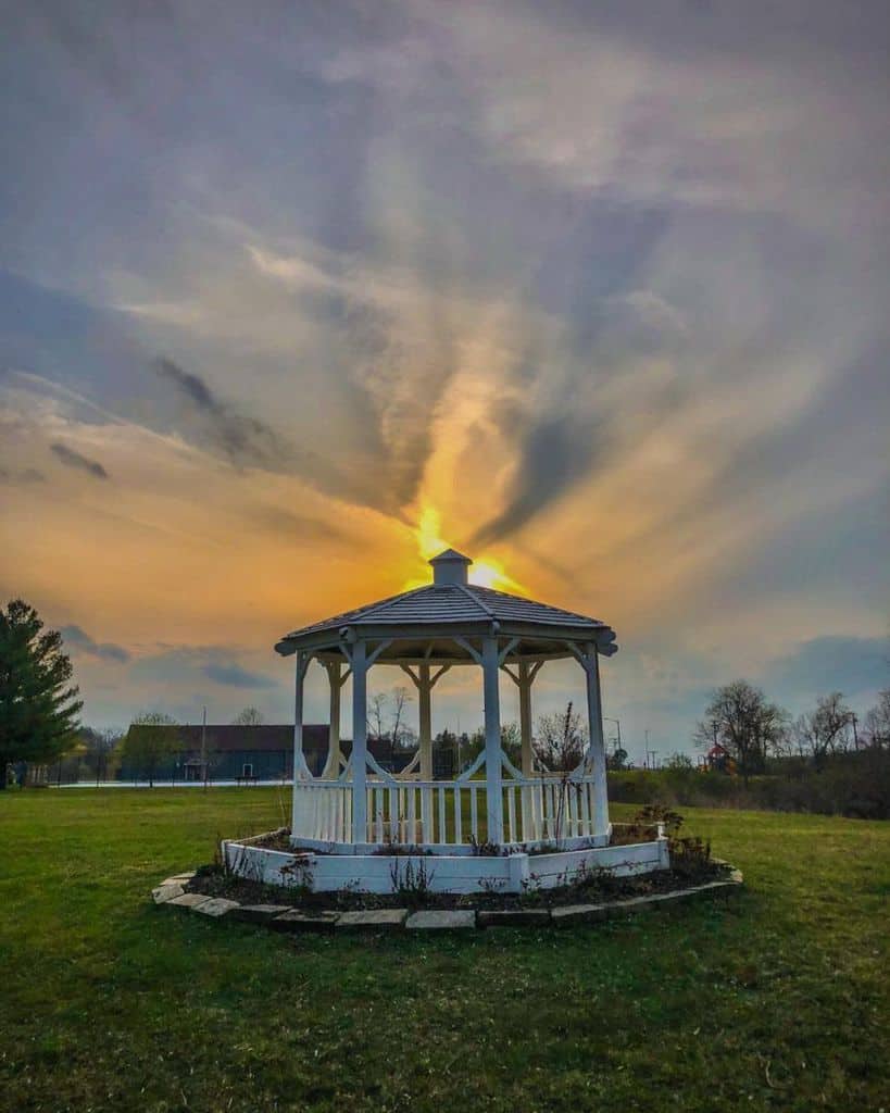 white gazebo large field stone edging garden