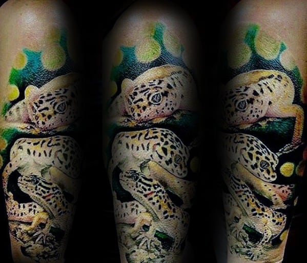 Realistic leopard gecko tattoo sleeve with multiple geckos, showcasing detailed patterns, lifelike eyes, and a vibrant jungle background.