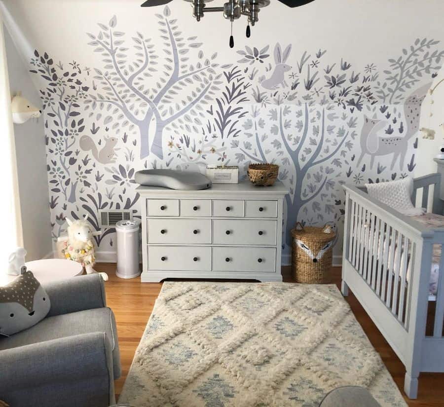 modern nursery gray crib and cabinets animal wall mural gray sofa chair