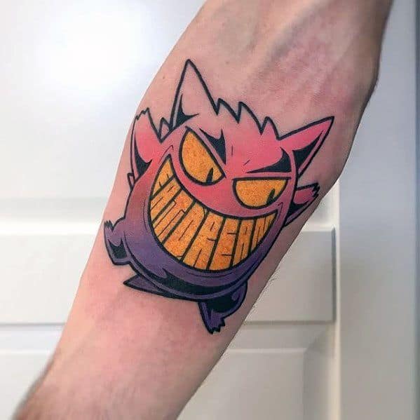 Stylized Gengar tattoo with bold lines, glowing yellow eyes, and a sharp grin featuring the word “Gengar” inside its teeth.