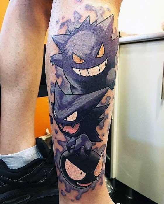 Leg tattoo showcasing the full evolution of Gastly, Haunter, and Gengar, with a smoky purple aura and bold, expressive faces.