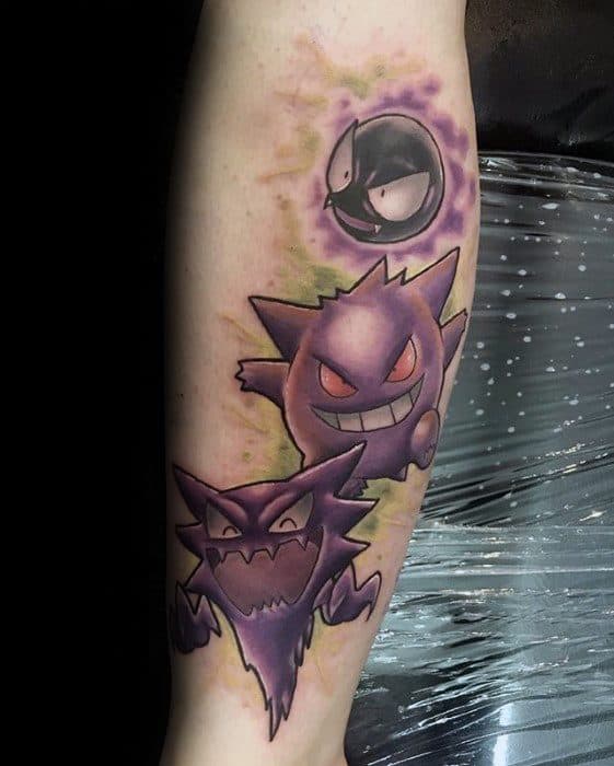 Colorful forearm tattoo of Gastly, Haunter, and Gengar in evolution order, with glowing eyes and a misty green and purple background.