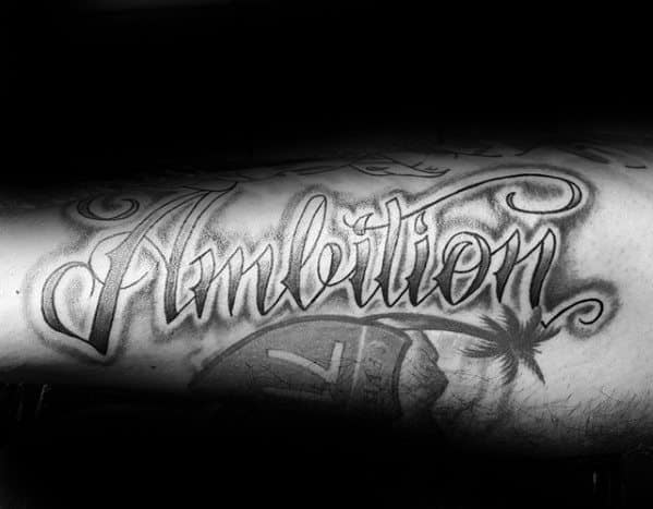 Black and white tattoo of "Ambition" in ornate script with palm tree and beach vibes