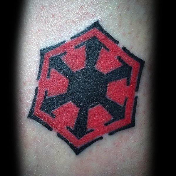 Bold red and black Sith Empire symbol tattoo with sharp geometric edges, centered on the skin with a clean, solid fill design.