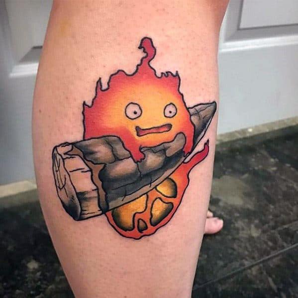 Bright Calcifer tattoo holding a large log, with fiery textures, glowing embers below, and a cheerful expression on the calf.