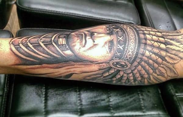 Realistic black and grey calf tattoo of a Native American chief with detailed facial features, a feathered headdress, and intricate shading