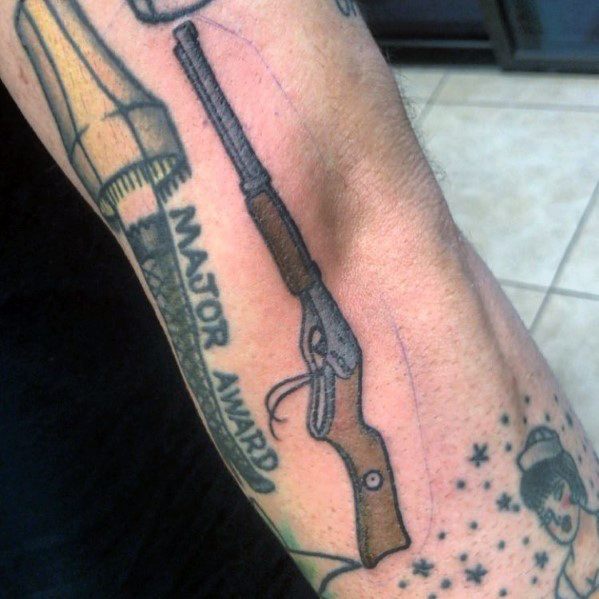 Christmas tattoo inspired by *A Christmas Story*, featuring the iconic leg lamp with "Major Award" text and a detailed Red Ryder BB gun design.