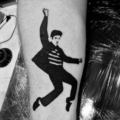 Bold black silhouette tattoo of Elvis Presley mid-dance, capturing his iconic Jailhouse Rock pose with one arm raised.