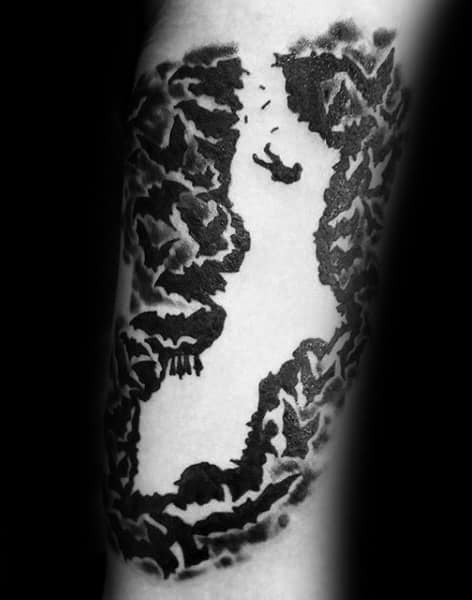 Blackwork tattoo of a person falling into a deep canyon surrounded by jagged cliffs, creating a dramatic and intense visual.