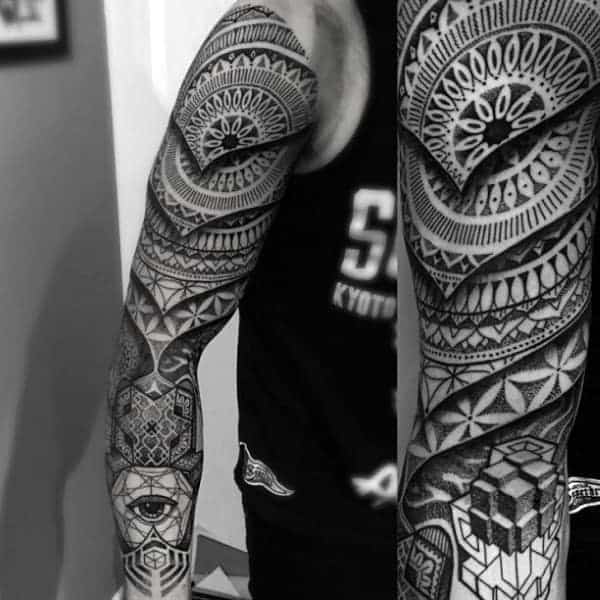 A detailed geometric full-sleeve tattoo featuring intricate mandala patterns, 3D cubes, and an all-seeing eye motif, creating a bold and visually striking design