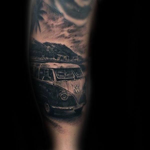 Dark-toned tattoo of a vintage Volkswagen van on a beach road with palm trees and stormy skies in the background.
