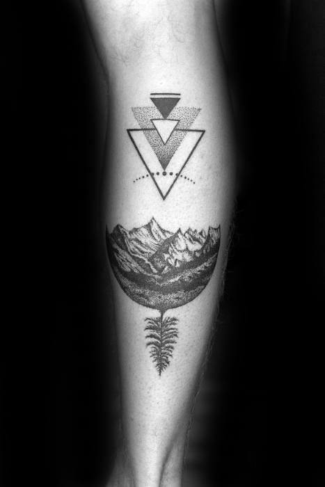 Detailed tattoo of a mountain landscape inside a half-circle with a tree root below, topped by dotted geometric triangles.