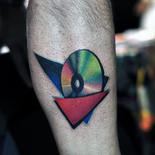 Gradient tattoo of a shiny CD with vivid rainbow reflections, layered over bold geometric shapes in red, blue, and black.