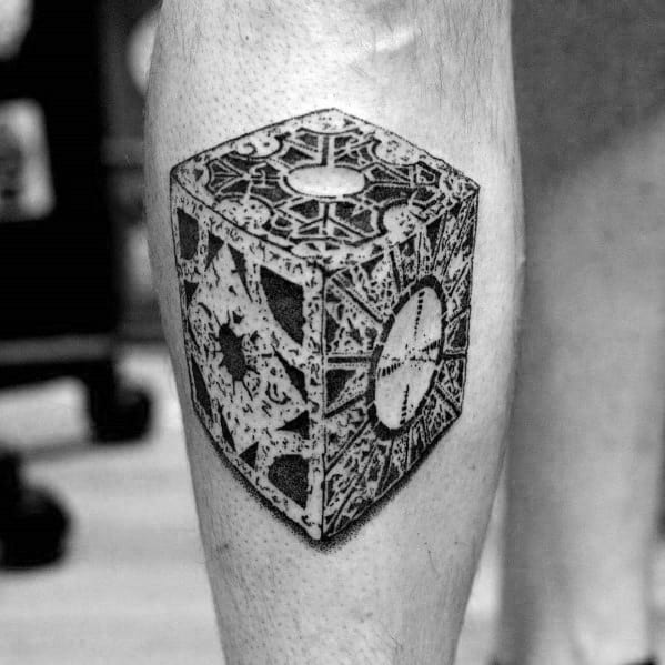 Black and grey tattoo of the Lament Configuration puzzle box from *Hellraiser*, featuring intricate patterns and detailed shading for depth.
