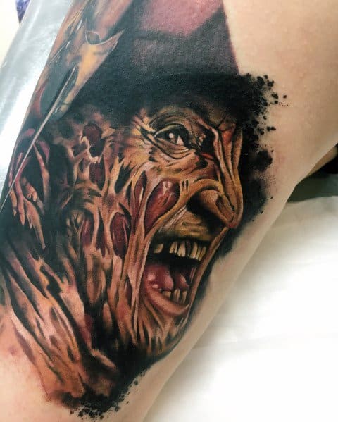 Realistic color tattoo of Freddy Krueger from *A Nightmare on Elm Street*, featuring his burned face, sinister expression, and eerie dark shading.