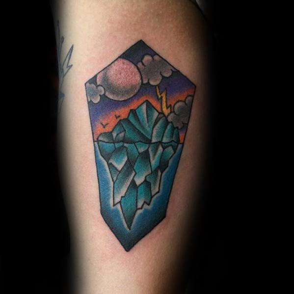 Bold geometric iceberg tattoo with glowing moon, lightning, and colorful night sky in a pentagon-shaped frame.