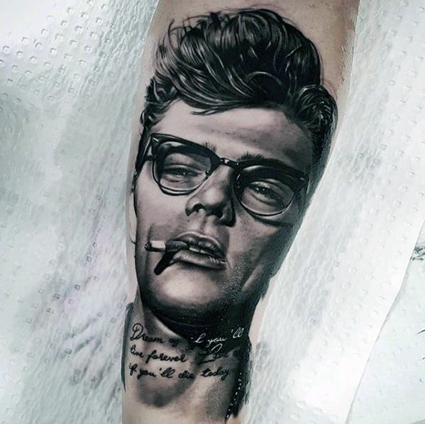 Realistic tattoo of James Dean with glasses and a cigarette, featuring a quote below that reads, "Dream as if you’ll live forever. Live as if you’ll die today."