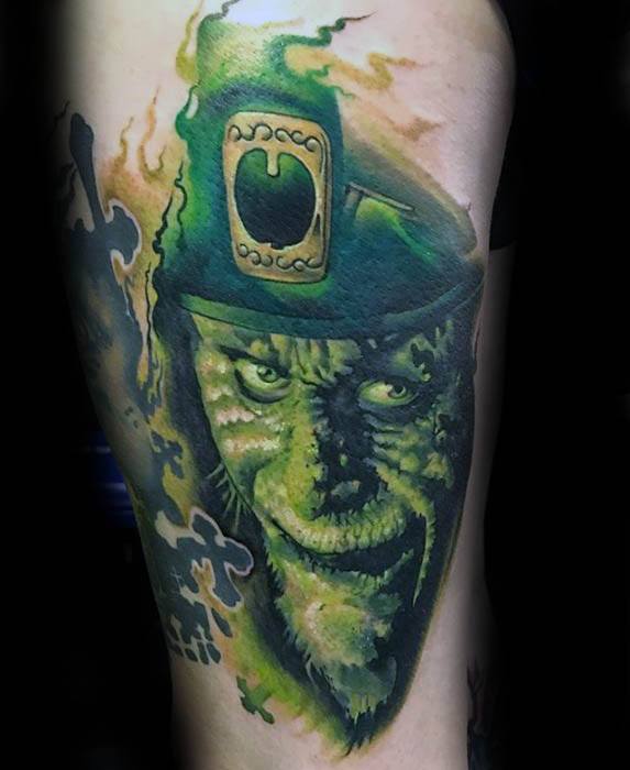 Dark and eerie leprechaun tattoo with glowing eyes, green skin, and a sinister grin, surrounded by swirling smoke and shadowy effects.