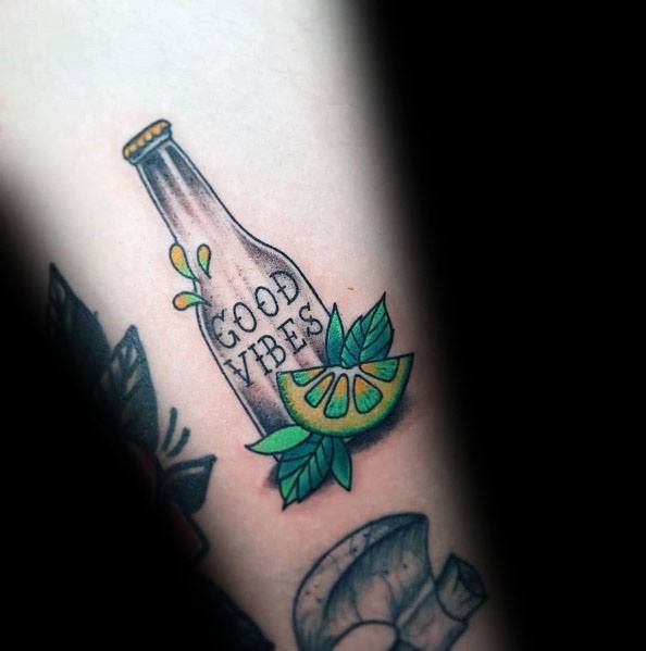 Colorful "Good Vibes" bottle tattoo with a lime wedge and leaves, blending a fun and refreshing citrus theme with a positive message.