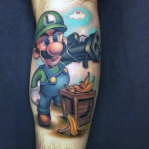 Colorful tattoo of Luigi holding a large cannon, standing next to a crate of bananas, with a bright background featuring clouds.