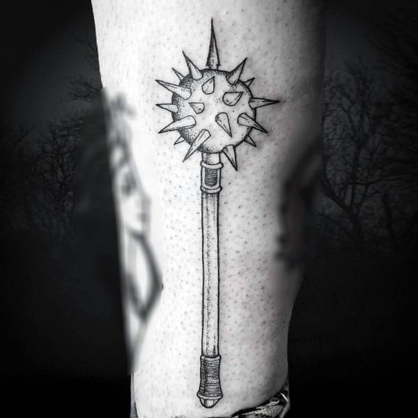 Detailed black and gray mace tattoo with a long handle and spiked ball, symbolizing power, strength, and medieval weaponry.