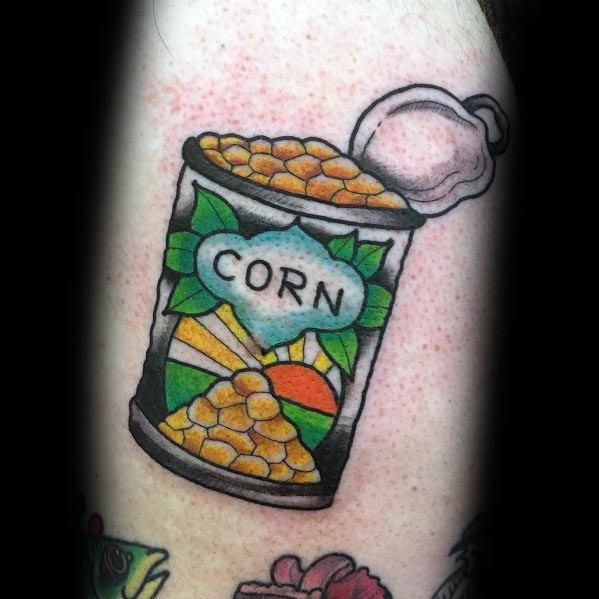 Colorful tattoo of an open canned corn with a scenic label featuring a sunset and leaves, creating a fun and unique design.