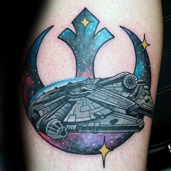 Millennium Falcon tattoo over a vibrant Rebel Alliance symbol filled with a starry galaxy background and glowing yellow stars.
