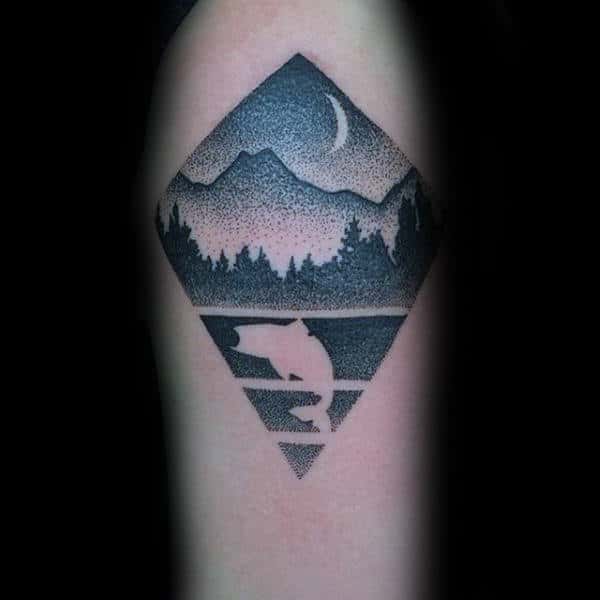 Tattoo of a bear, forest, mountains, and crescent moon inside a diamond shape