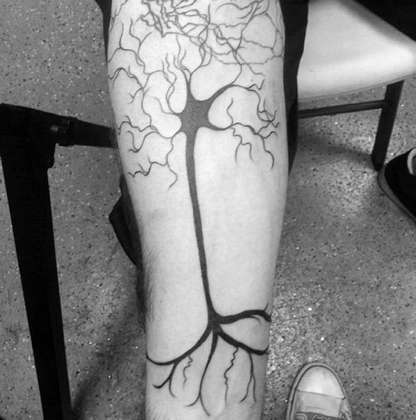 Bold black neuron tattoo on leg with thick axon and branching dendrites extending toward the knee and ankle.