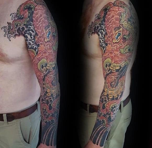 Intricate dragon tattoo sleeve on a man's upper arm and shoulder