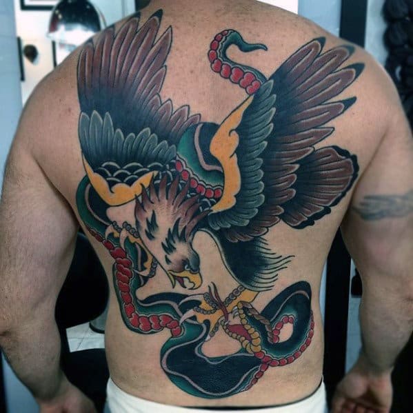Back tattoo of an eagle with spread wings, holding a snake in its talons and beak