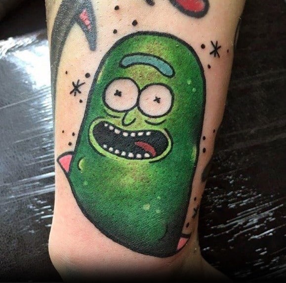 Bright and playful Pickle Rick tattoo with bold outlines, green shading, and a cartoonish expression, placed on the ankle.