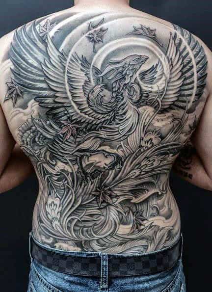 A man with a detailed, black and gray phoenix tattoo covering his entire back