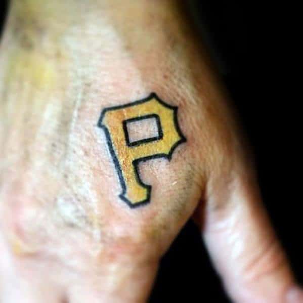 Small gold Pittsburgh Pirates "P" tattoo with a black outline, placed subtly on the back of the hand for a minimalist look.
