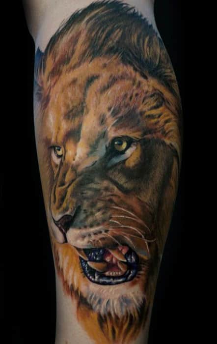 Realistic lion tattoo on forearm, showing the lion's intense gaze and open mouth