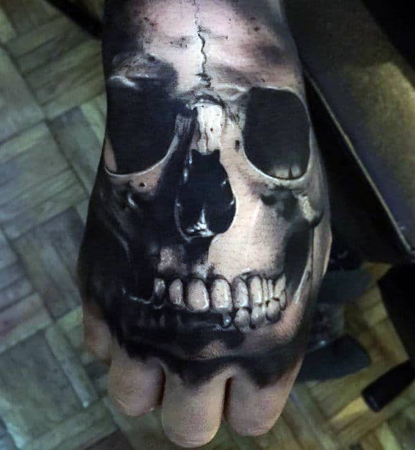 Tattoo of a realistic skull covering the back of a person's hand
