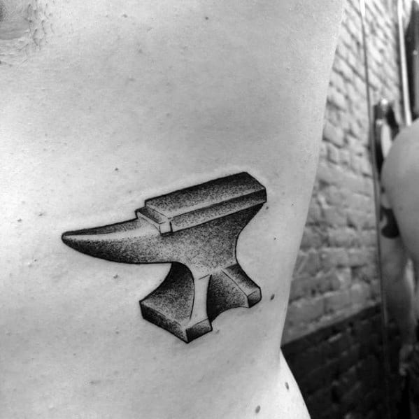 Dotwork anvil tattoo on the ribcage with clean lines and smooth shading for a bold yet minimalist look.