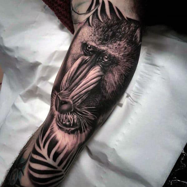 Black and grey realistic baboon tattoo with intricate shading, intense gaze, and jungle elements, creating a bold and detailed sleeve design.