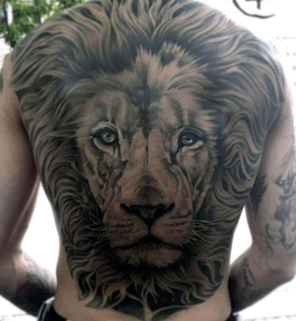 Detailed lion face tattoo covering a person's entire back with intricate shading